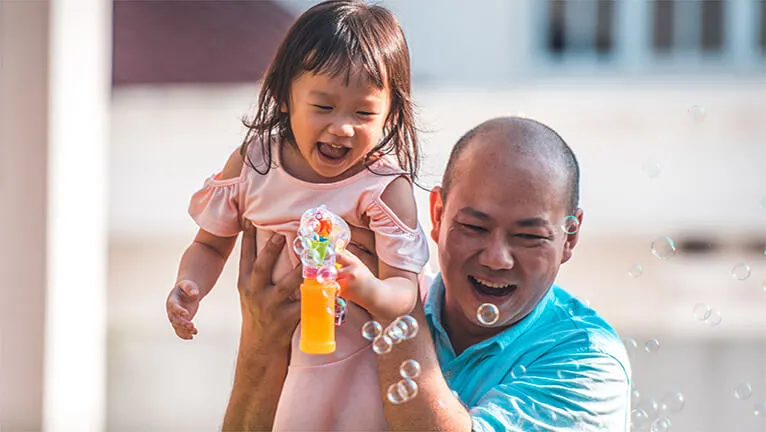 Father and daughter playing bubbles 