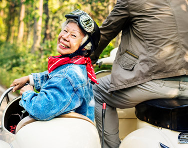 Senior Asian lady riding in a motorbike with sidecar